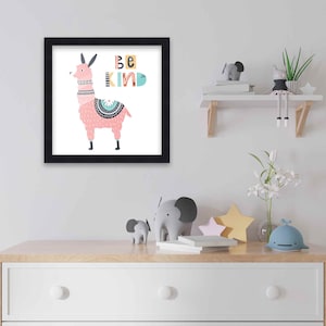 May include: A framed print with a pink llama with a colorful patterned saddle and the text "Be Kind" in colorful letters.