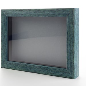 May include: A teal wood picture frame with a clear glass front. The frame is empty and ready to display a photo or other artwork.
