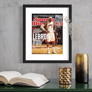 May include: Sports Illustrated magazine cover featuring LeBron James in a red and black Miami Heat jersey, with the text "LEBRON" in large white letters and the quote "Last touch with who I was as a basketball player and a person."
