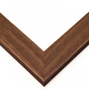 May include: Close-up of a corner of a brown wood picture frame with a wood grain texture.