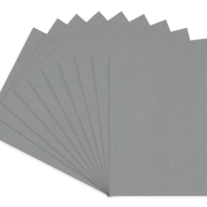 May include: A pack of 12 sheets of silver glitter cardstock. The sheets are stacked and fanned out, showing the shimmery silver color.