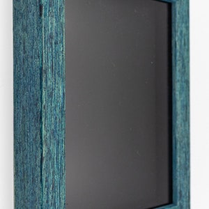 May include: A teal blue picture frame with a black mat. The frame is made of wood and has a distressed finish.