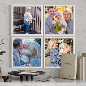 May include: A set of four square white frames displaying family photographs, featuring a child in a white hat and blue jeans, a family of three outdoors, a couple kissing a child, and a family walking, with a book labeled tine&home nearby.
