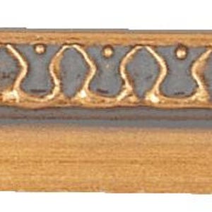 May include: A section of decorative picture frame molding. The top edge features a repeating gold-colored pattern on a gray background. The lower section is a light brown color with a wood grain texture.
