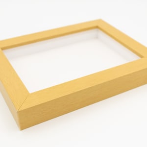 May include: A light wood picture frame with a simple design. The frame is empty and ready to display a photo or artwork.