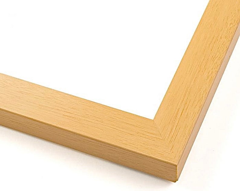 May include: A close-up of the corner of a light wood picture frame. The frame has a simple, clean design and a natural wood finish.