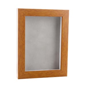 May include: A wood picture frame with a light brown finish. The frame is empty and ready for a photo or artwork.