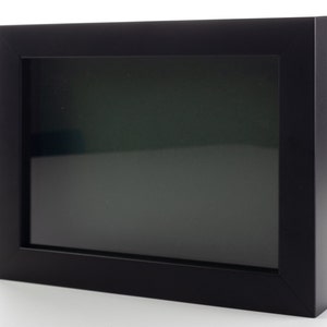 May include: A black picture frame with a black mat and a clear glass front. The frame is empty.