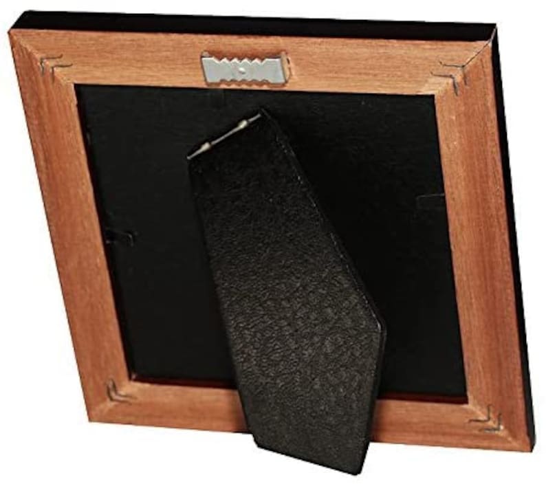May include: A wooden picture frame with a black mat and a black easel stand. The frame has a dark wood finish and a simple design.