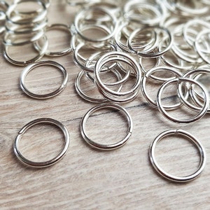 Op de afbeelding: Een grote stapel zilveren springringen, een soort metalen ring die wordt gebruikt bij het maken van sieraden en handwerk.
