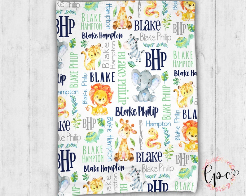 May include: White baby blanket with a repeating pattern of jungle animals, including giraffes, lions, and elephants. The blanket features the name "Blake Philip" and the initials "BHP" in navy blue and green.
