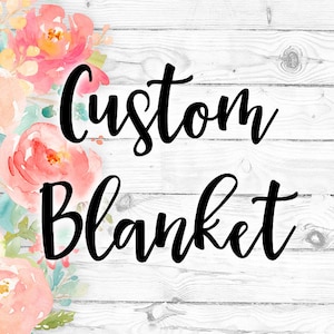 May include: Custom Blanket written in black cursive script on a white wood background with a watercolor floral design in pink, yellow, and blue.