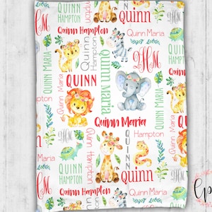 May include: A white baby blanket with a jungle animal theme. The blanket features a repeating pattern of giraffes, zebras, elephants, lions, snakes, and turtles. The blanket is personalized with the name "Quinn" and the initials "HM".