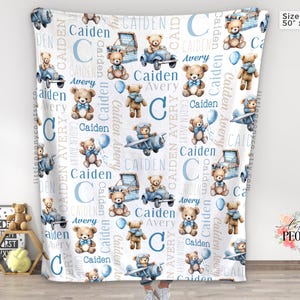 May include: A white baby blanket with a repeating pattern of teddy bears, blue vehicles, and the names "Caiden" and "Avery." The blanket measures 50 inches by 60 inches.
