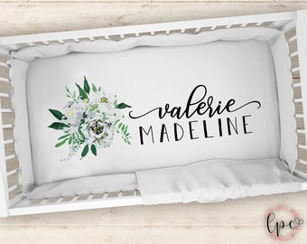 Puede incluir: Sábana de cuna blanca con un diseño floral y el nombre "Valerie Madeline" en letra cursiva negra.