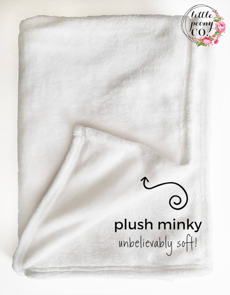 Puede incluir: Una manta de minky blanca, doblada por la mitad, con el texto "plush minky unbelievably soft!" y una peque&ntilde;a flecha que apunta al tejido.