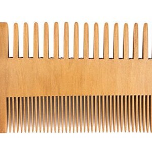 May include: A wooden comb with two rows of teeth. The comb is light brown and has a rounded shape.