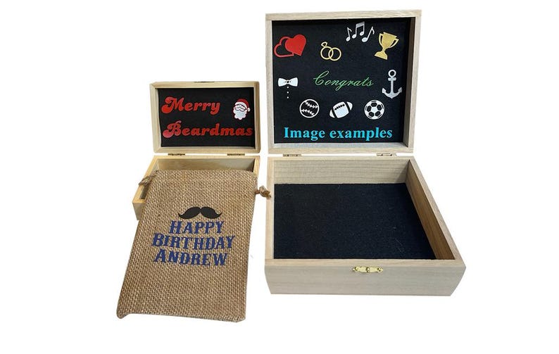 May include: Two light-colored wooden boxes with hinged lids and black interior linings. The smaller box lid interior reads Merry Beardmas with a Santa icon. A burlap drawstring bag reads HAPPY BIRTHDAY ANDREW. The larger box lid shows various icons.
