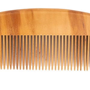 May include: A wooden comb with a natural brown finish and a curved shape. The comb has fine teeth and is designed for detangling and styling hair.