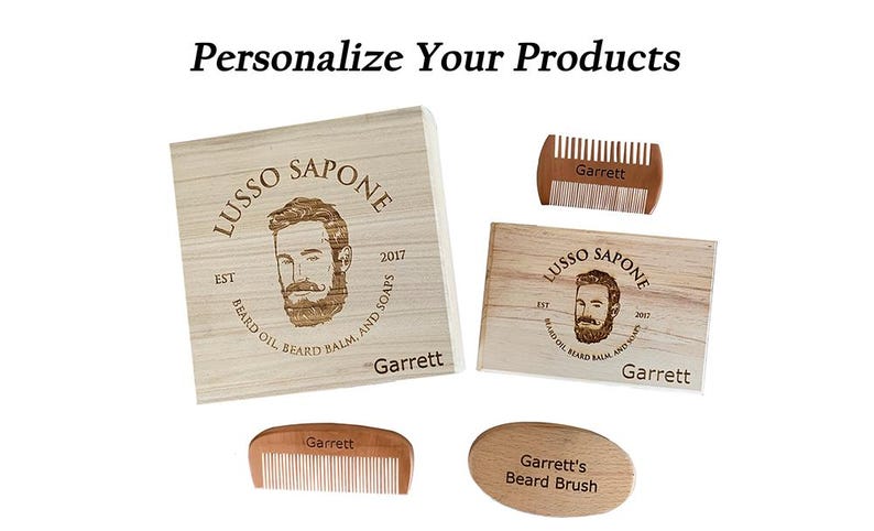 May include: A set of personalized wooden beard care products with the name "Garrett" engraved on each item. The set includes a wooden box, a comb, a brush, and a smaller wooden box. The boxes feature a logo with a man's face and the text "Lusso Sapone Est 2017 Beard Oil Beard Balm And Soaps".