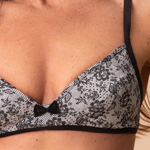 Pu&ograve; includere: Un bralette in pizzo bianco e nero con un fiocco nero al centro. Il bralette ha spalline regolabili.