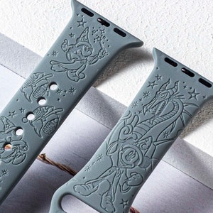 May include: Two grey silicone watch straps with embossed cartoon character designs. One strap features a wizard character with stars, and the other has a dragon design. The straps have multiple holes for adjustment and a silver clasp.