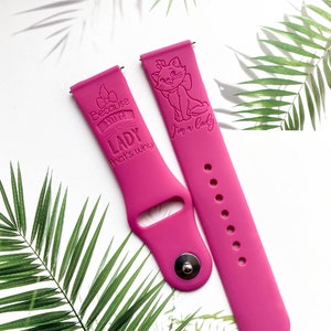 Op de afbeelding: Roze siliconen horlogeband met een kattenillustratie en de tekst "Because I'm a Lady that's why".