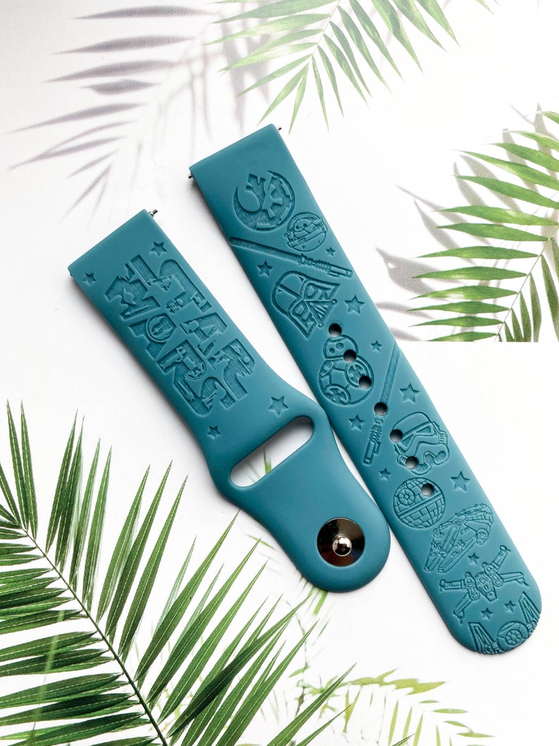 K&ouml;nnte beinhalten: Zwei tealblaue Silikon-Armb&auml;nder mit gepr&auml;gten Star Wars-Charakteren und dem Text "Star Wars".