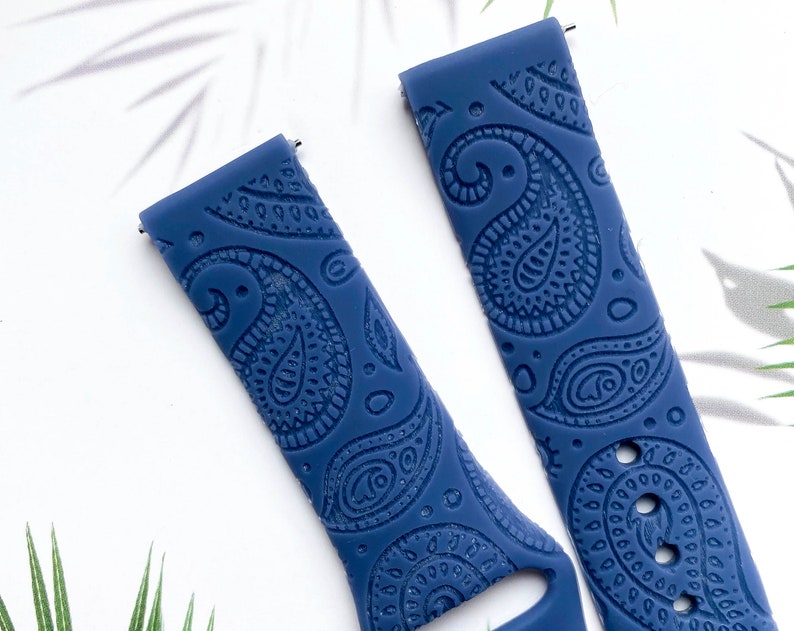 May include: Two blue silicone watch bands with a paisley pattern. The bands are made of a soft, flexible material and have a comfortable fit.