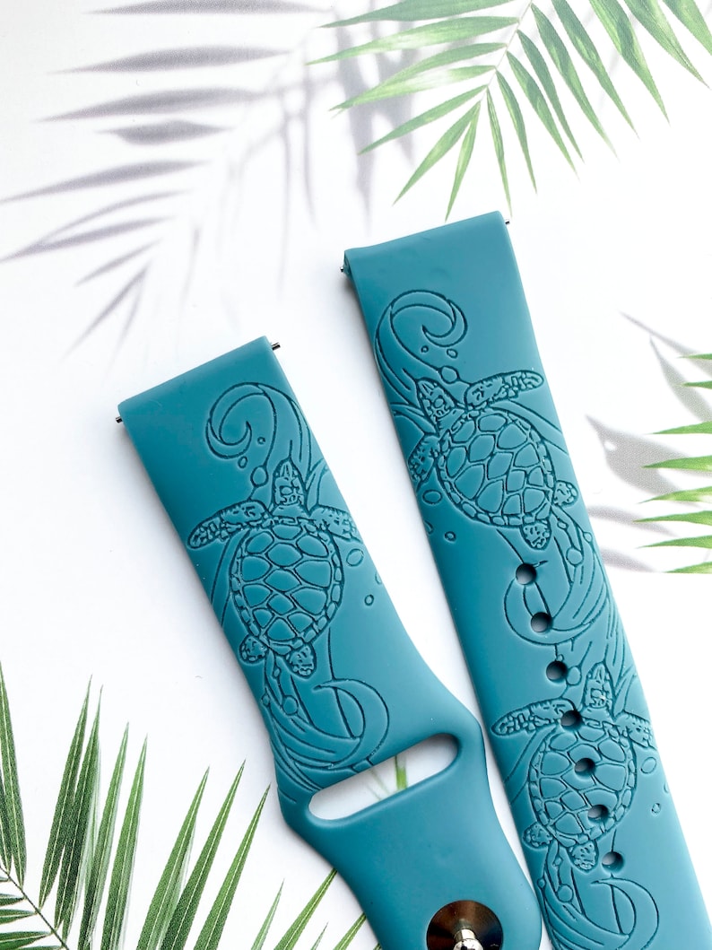 May include: Two teal blue silicone watch bands with a sea turtle design. The bands have a raised design of a sea turtle swimming in the ocean.