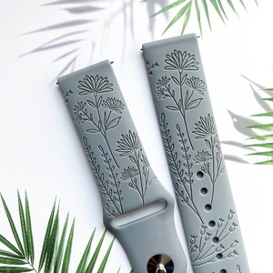 May include: Two gray silicone watch bands with an embossed floral design. The bands are made of a soft, flexible material and are compatible with most smartwatches.