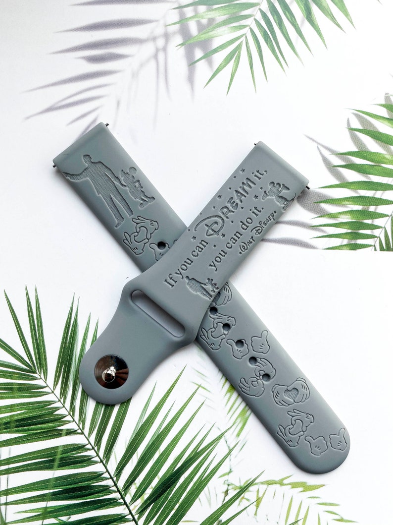 May include: Grey silicone watch band with a Mickey Mouse design and the text "If you can dream it, you can do it."  "Walt Disney"