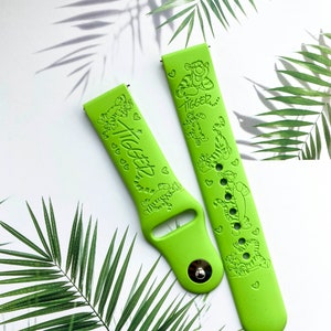 May include: Two green silicone watch bands with a cartoon tiger design and the text "Tigger" printed on them.