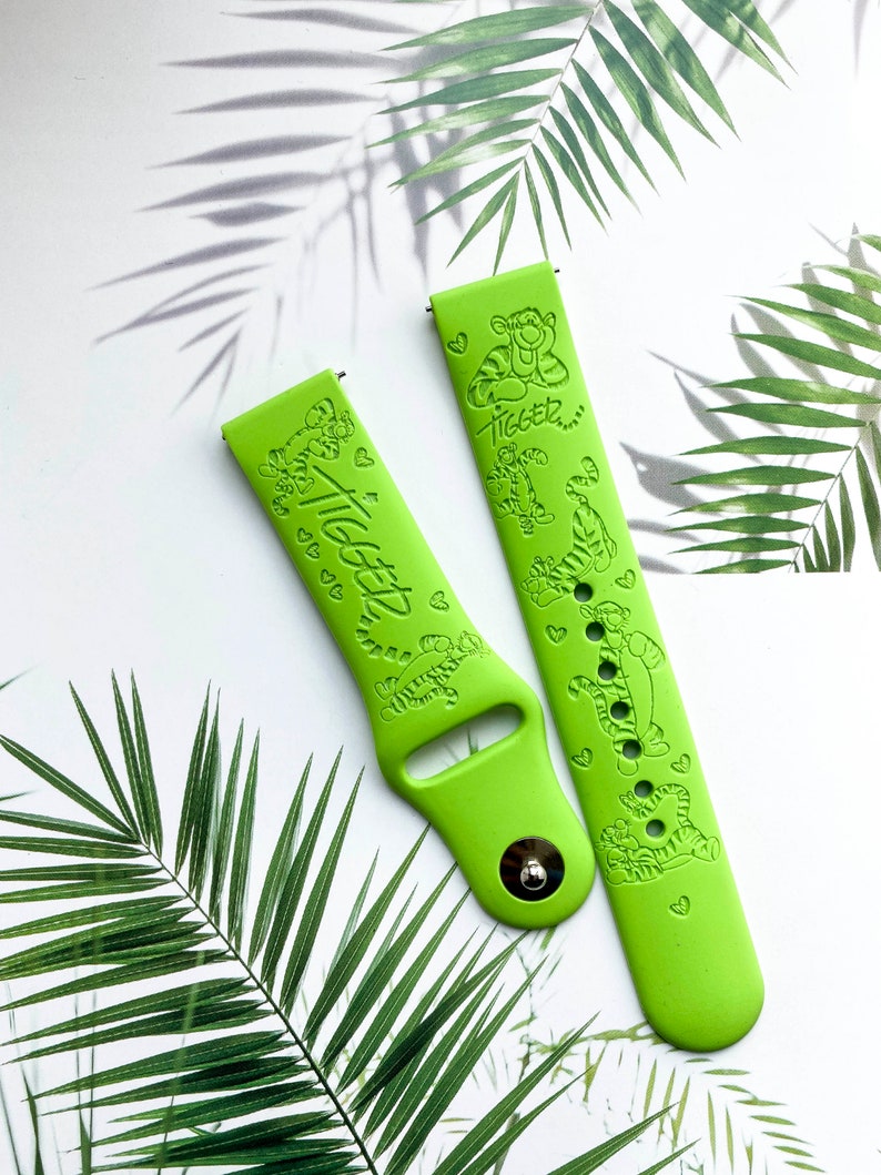 May include: Two green silicone watch bands with a cartoon tiger design and the text "Tigger" printed on them.