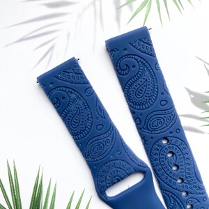 May include: A pair of blue silicone watch bands with a paisley pattern. The bands are designed for smartwatches.