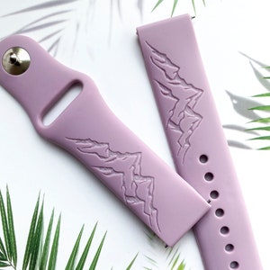 K&ouml;nnte beinhalten: Zwei lavendelfarbene Silikon-Armb&auml;nder mit einem gepr&auml;gten Bergketten-Design auf der Vorderseite. Die Armb&auml;nder sind f&uuml;r Smartwatches konzipiert.