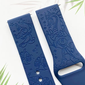 May include: Two blue silicone watch bands with a Mickey Mouse design. One band features Mickey Mouse as a sorcerer with a star pattern. The other band features Mickey Mouse with a dragon and a star pattern.