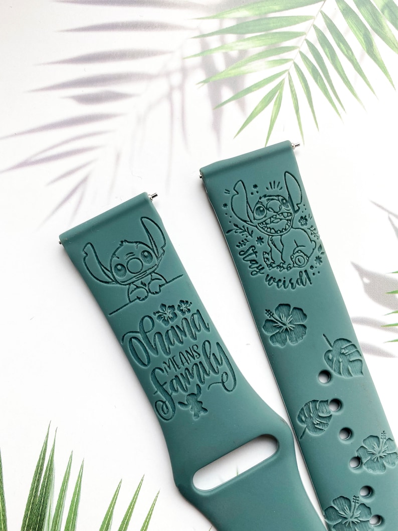 Op de afbeelding: Twee tealblauwe siliconen horlogebandjes met een Stitch-ontwerp. E&eacute;n bandje heeft de tekst "Ohana means family" en het andere bandje heeft Stitch met de tekst "Stay weird".