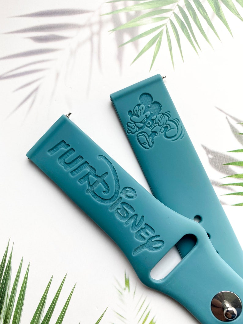 May include: Two teal blue silicone watch bands with a Mickey Mouse design and the text "Disney" embossed on them.