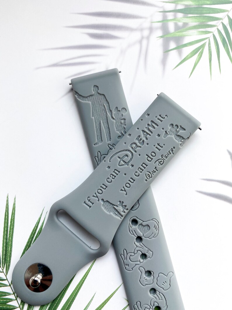 May include: Grey silicone watch strap with a white inscription that reads "If you can dream it, you can do it. Walt Disney". The strap also features a silhouette of Mickey Mouse and a silhouette of Walt Disney.