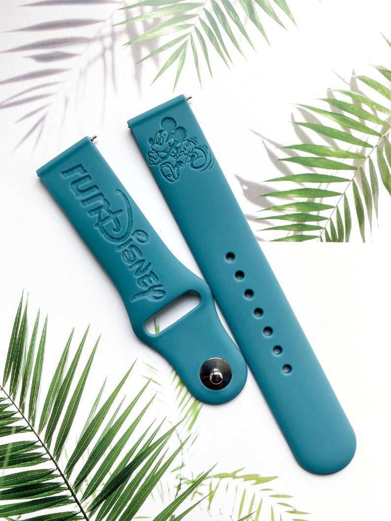 May include: Two teal blue silicone watch bands with a Mickey Mouse design and the text "WALT DISNEY" embossed on one band.