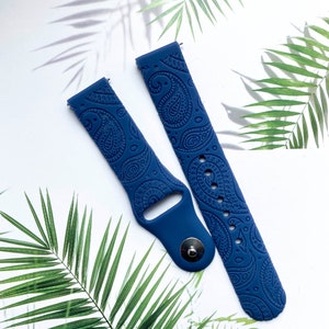 May include: A pair of blue silicone watch bands with a paisley pattern. The bands are designed for smartwatches.