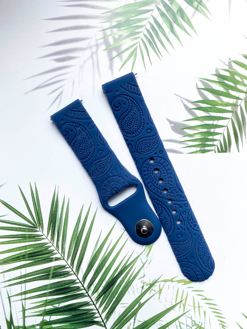 May include: A pair of blue silicone watch bands with a paisley pattern. The bands are designed for smartwatches.