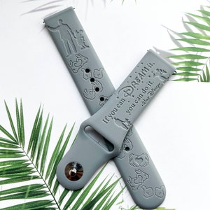 May include: Grey silicone watch strap with a white inscription that reads "If you can dream it, you can do it.  Walt Disney."  The strap is decorated with Mickey Mouse hand silhouettes.