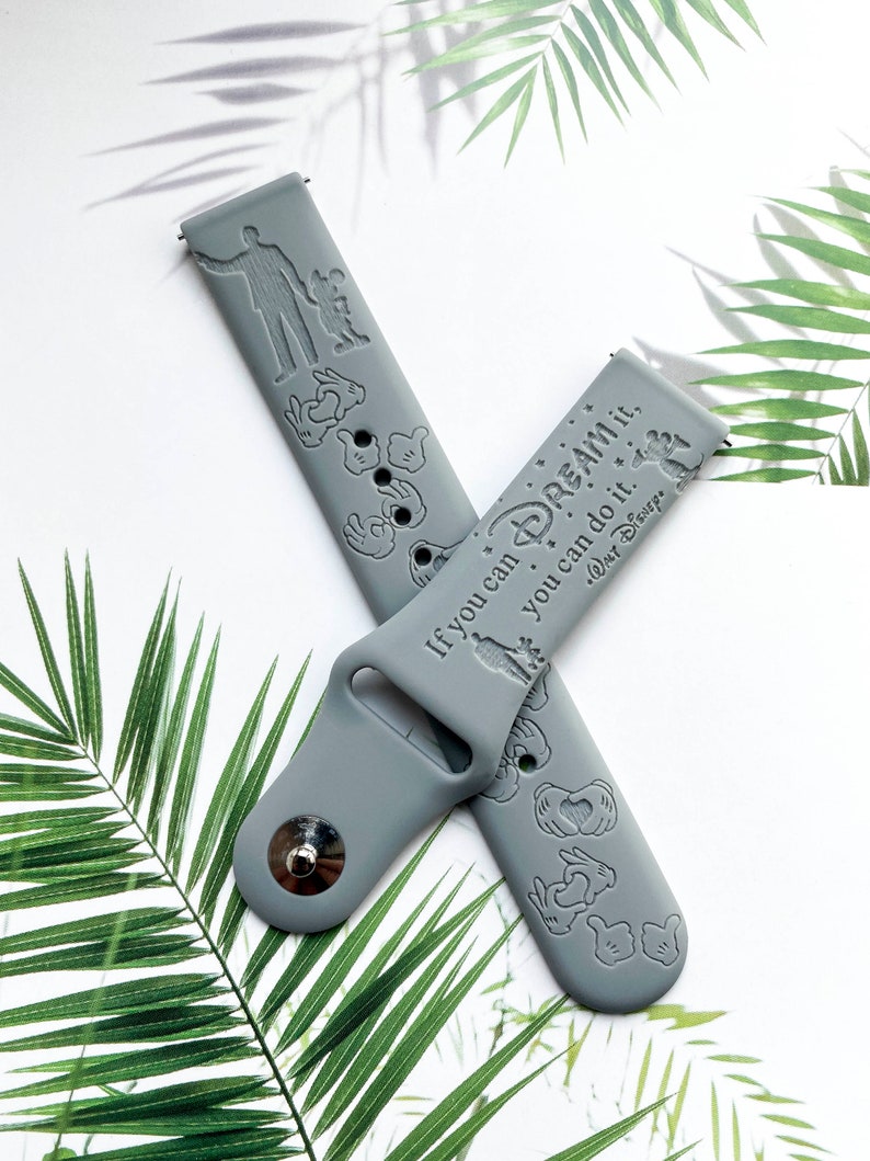 May include: Grey silicone watch strap with a white inscription that reads "If you can dream it, you can do it.  Walt Disney."  The strap is decorated with Mickey Mouse hand silhouettes.