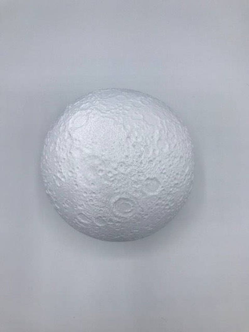 May include: A white, spherical moon lamp with a textured surface that resembles the surface of the moon.