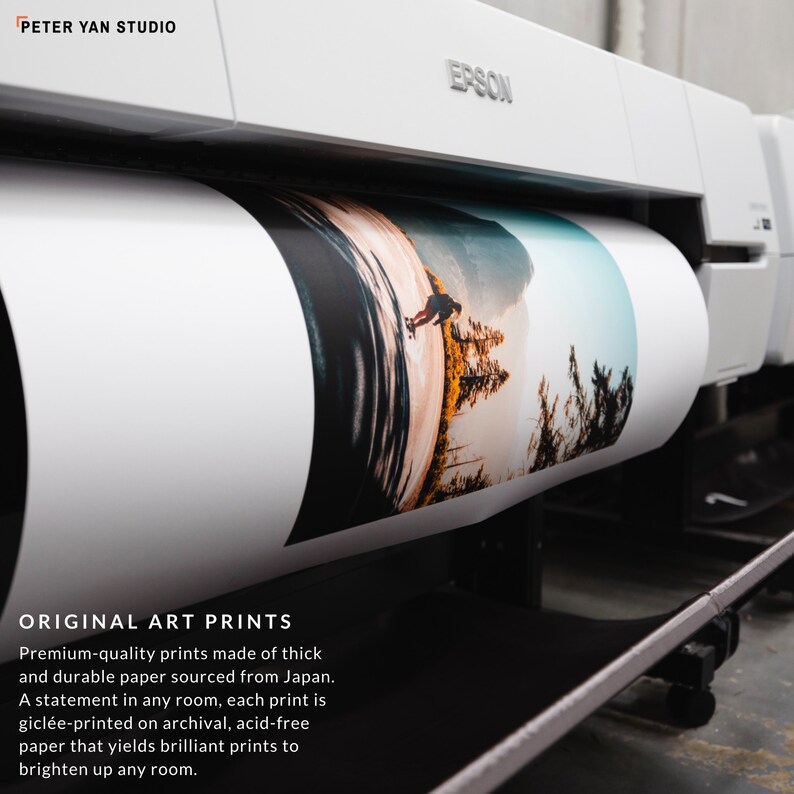 May include: A white Epson printer with a roll of paper printing a colourful landscape photograph. The text "ORIGINAL ART PRINTS" is visible below the printer. The text reads "Premium-quality prints made of thick and durable paper sourced from Japan. A statement in any room, each print is gicl&eacute;e-printed on archival, acid-free paper that yields brilliant prints to brighten up any room."