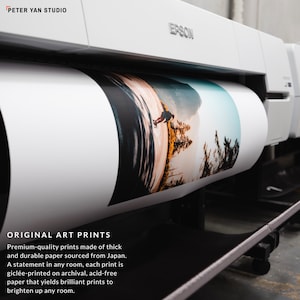 May include: A white Epson printer with a roll of paper printing a colorful landscape photograph. The text "ORIGINAL ART PRINTS" is visible below the printer. The text reads "Premium-quality prints made of thick and durable paper sourced from Japan. A statement in any room, each print is gicl&eacute;e-printed on archival, acid-free paper that yields brilliant prints to brighten up any room."