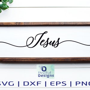 May include: A wooden sign with the word "Jesus" written in cursive script. The sign is on a white background with a black and white checkered ribbon and green foliage.