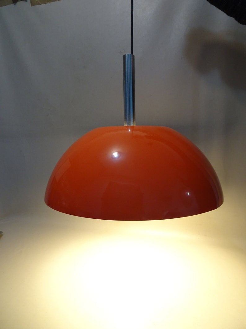 May include: A red dome-shaped pendant light fixture with a silver metal hanging rod.